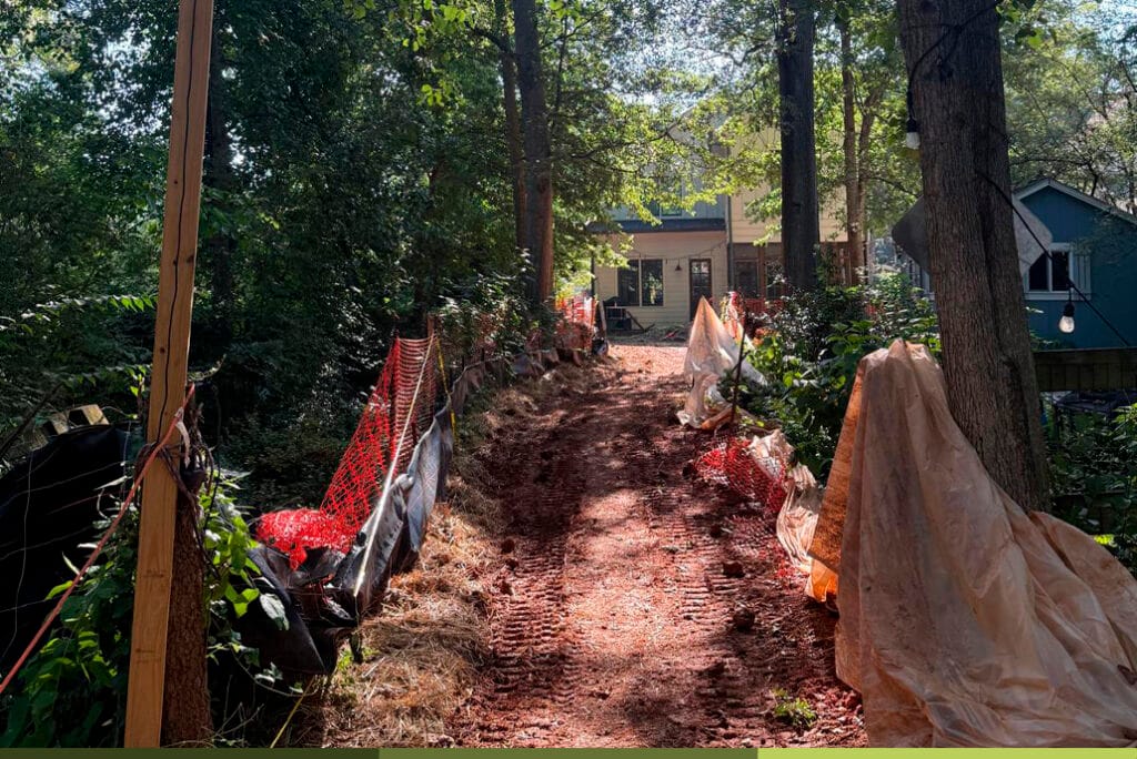 a dirt road with trees and a house