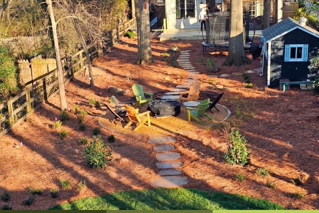 a backyard with a fire pit and chairs